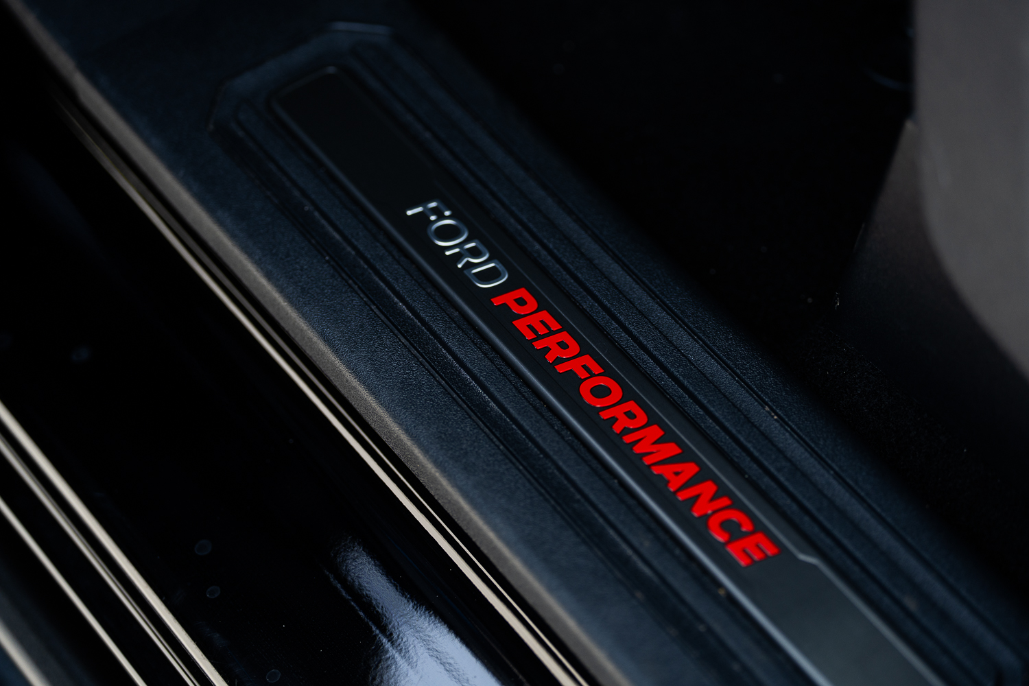 FORD PERFORMANCE feliratos küszöb-díszléc a Bronco Raptor Orange Edition beltéri belépőjén