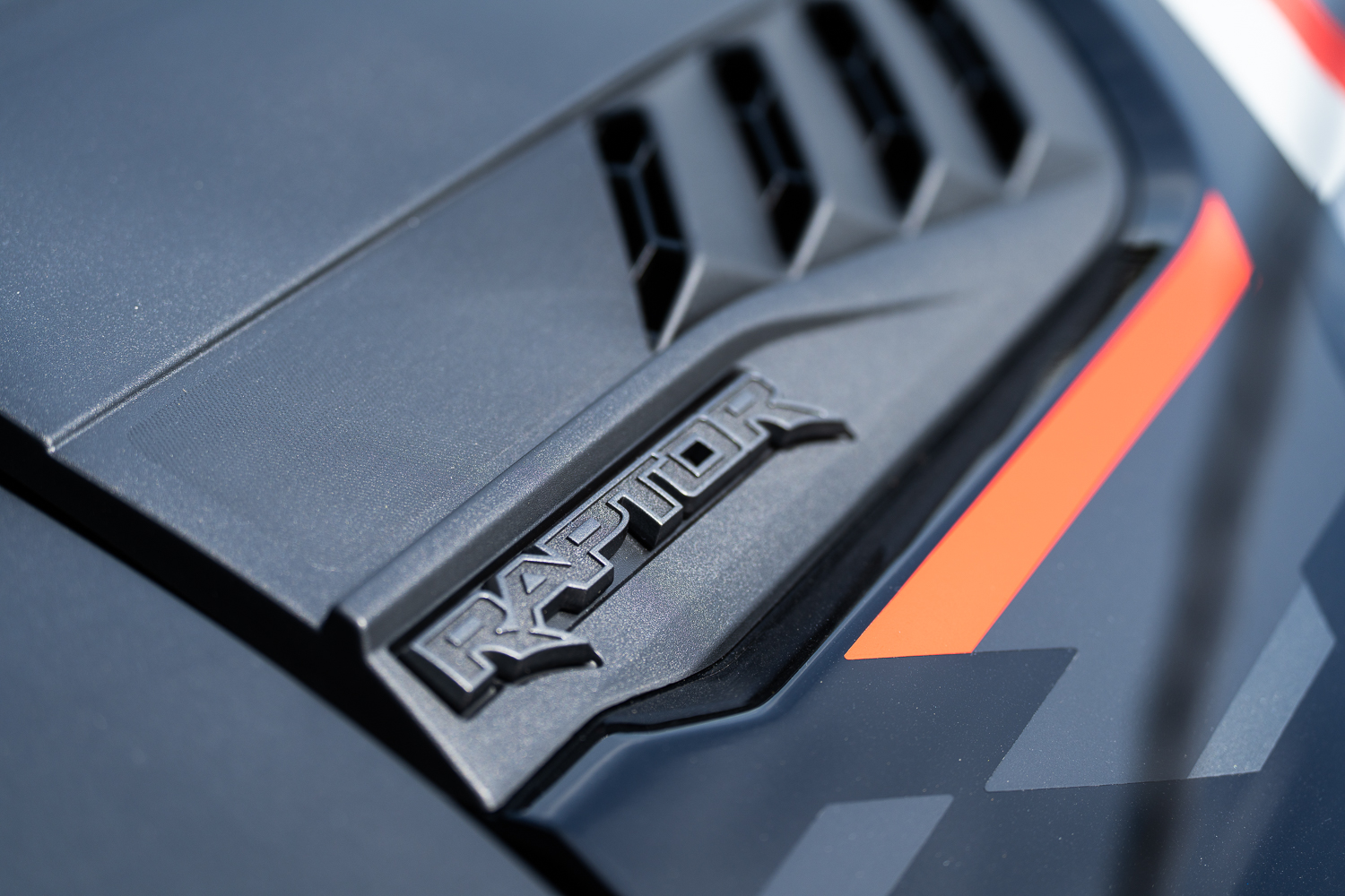 Ford Bronco Raptor motorháztetőjének légterelője a Code Orange sávval és RAPTOR emblémával