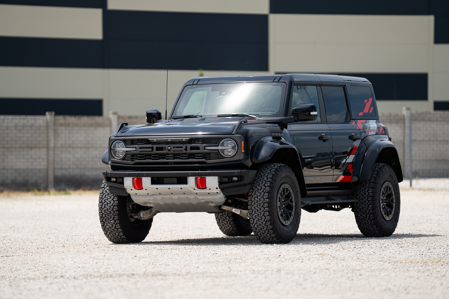 Fekete Ford Bronco Raptor Orange Edition 3/4-es elölnézetből, Code Orange grafikákkal a hátsó sárvédőn