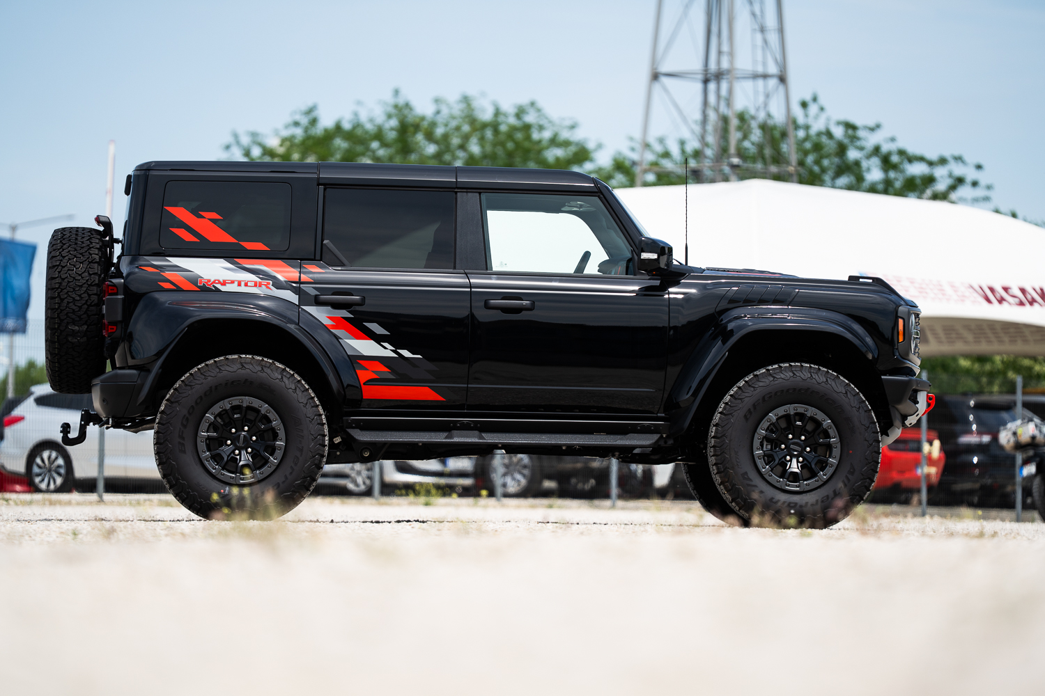 Ford Bronco Raptor Orange Edition teljes oldalnézet fekete karosszériával, Code Orange RAPTOR grafikával és 37 colos BFGoodrich terepgumikkal